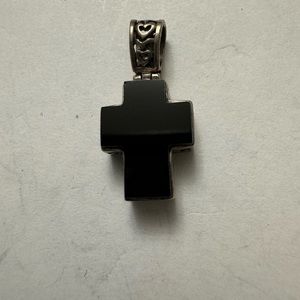 A cross in onyx on one side and silver ornate on the other side.